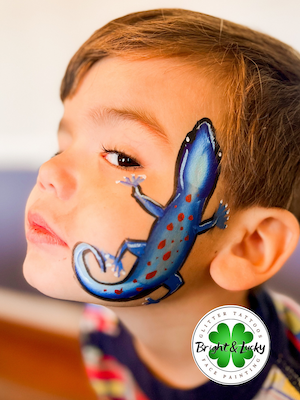 Smiling face with a custom face paint design: blue lizard cheek.