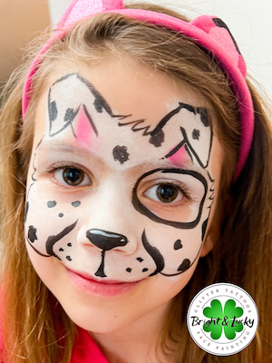 Smiling face with a custom face paint design: dalmation mask.