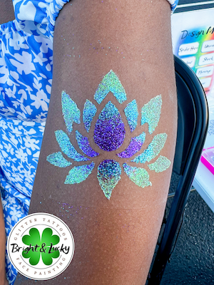 Smiling face with a custom face paint design: glitter lotus.