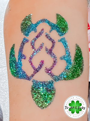 Smiling face with a custom face paint design: glitter turtle.