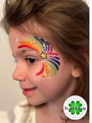 Smiling face with a custom face paint design: rainbow starburst.