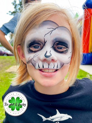 Smiling face with a custom face paint design: skull mask.