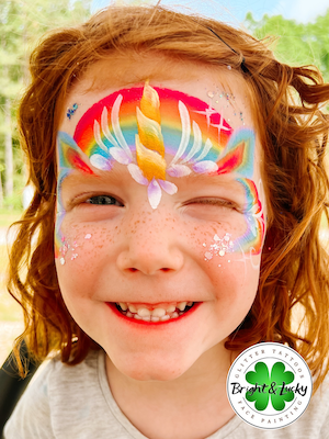 Smiling face with a custom face paint design: unicorn crown 2.