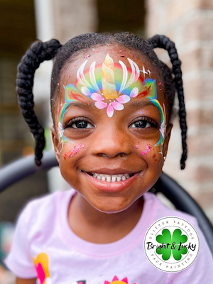 Smiling face with a custom face paint design: unicorn crown.