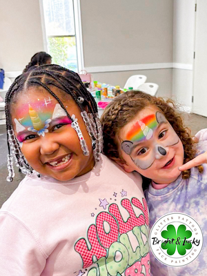 Smiling face with a custom face paint design: unicorn friends.